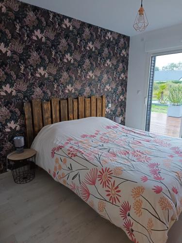 une chambre avec un lit avec un couvre-lit fleuri dans l'établissement La Celthane, à Saint-Germain-sur-Ay