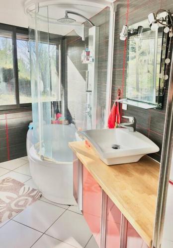 une salle de bain avec un lavabo, une baignoire et des toilettes dans l'établissement Maison d’archi 80’s avec piscine et toboggan, à Ventenac-Cabardès