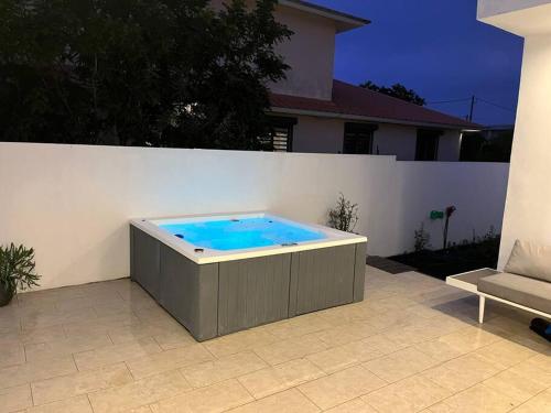 una bañera de hidromasaje junto a una pared blanca en Entre ciel et mer, en Grand Baie