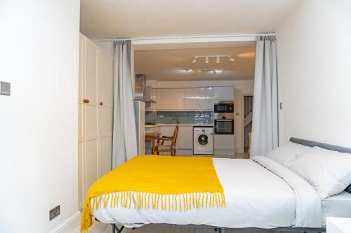 a bedroom with a bed with a yellow blanket at The Perfect Spot in Alpha Grove in London