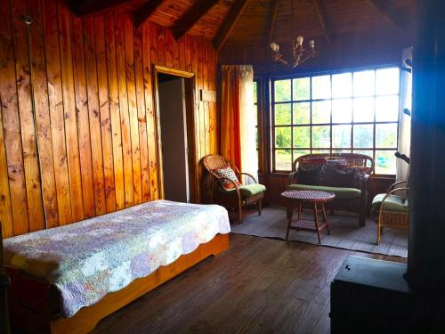 een slaapkamer met een bed in een houten kamer bij Cabañas Los Bajos in Frutillar