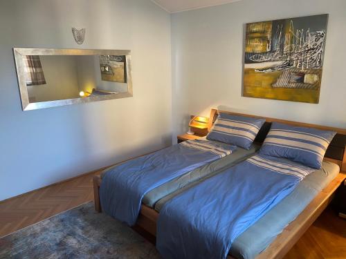 um quarto com uma cama com lençóis azuis e um espelho em Apartment Meerblick Opatija (Icici) em Ičići