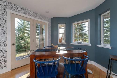 comedor con paredes azules, mesa y sillas en Apres Chalet Luxury Town Home off Ski Hill Rd, en Driggs