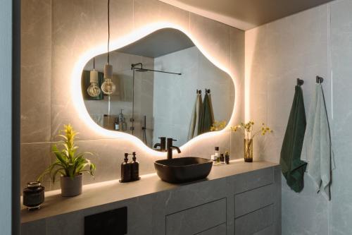 y baño con lavabo y espejo. en Luxurious Penthouse, Expansive Wrap-Around Terrace en Londres