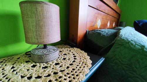una lámpara sentada en una mesa junto a una cama en The Green Room Homestay, en Galway