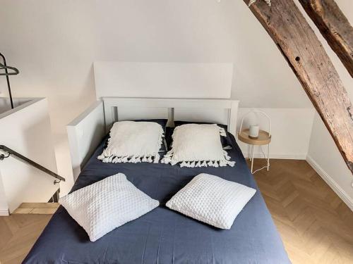 uma cama com duas almofadas num quarto em L'Hippolyte - Cœur de ville em Compiègne