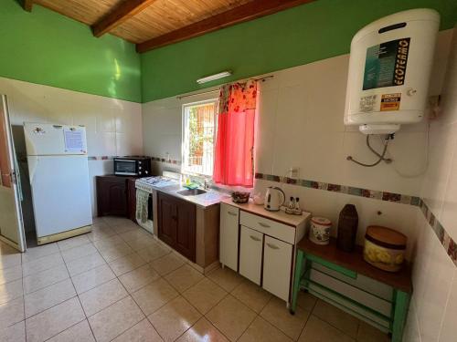 a kitchen with green walls and a white refrigerator at La Casita de Irene in Puerto Rico