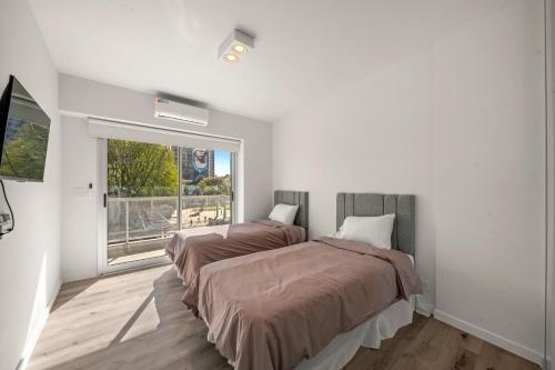 two beds in a room with a window at La Vie Suite Barrio Norte in Buenos Aires