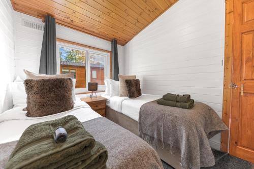 a bedroom with two beds and a window at Bowness 45 - 2 bedroom Lake Windermere Lodge in Windermere