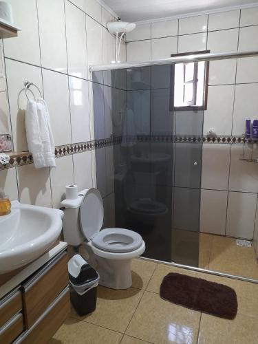 uma casa de banho com um WC, um lavatório e um chuveiro em Casa refúgio em Santana do Livramento