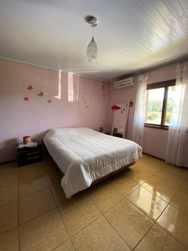 una camera da letto con un letto grande e una finestra di Casa refúgio a Santana do Livramento
