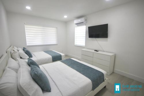 a bedroom with two beds and a flat screen tv at 251 Airport/Top House Apartments in Miami