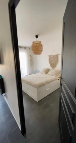 une chambre avec un lit blanc et un miroir dans l'établissement Appartement vert, à Corbeil-Essonnes