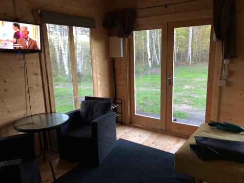 Saare-Toominga camping house في Väike-Rakke: غرفة معيشة مع تلفزيون وطاولة وكراسي