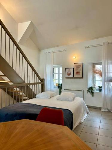 a bedroom with a large bed and a staircase at Duplex en plein centre-ville in Morestel