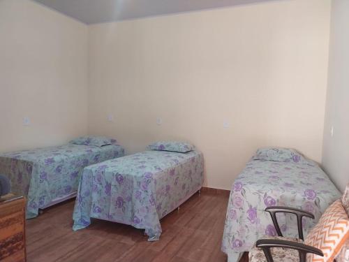 a room with two twin beds and two chairs at Pousada Canela de Ema in Mateiros