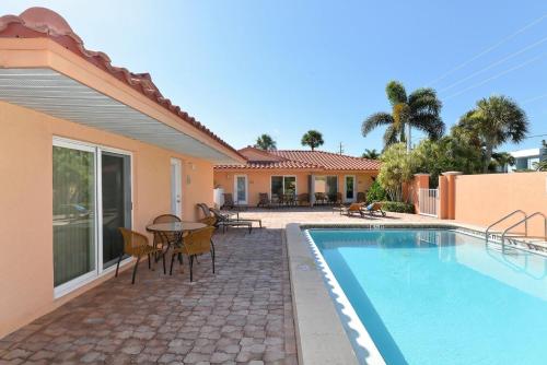 a house with a swimming pool and a table and chairs at The Villas 2B in Holmes Beach