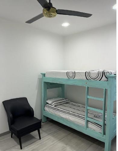 ein blaues Etagenbett mit einem Deckenventilator und einem Stuhl in der Unterkunft Hermosa casa Ricaurte in Girardot