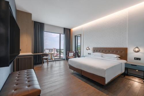 a bedroom with a large bed and a large window at Four Points by Sheraton Taipei Bali in Bali