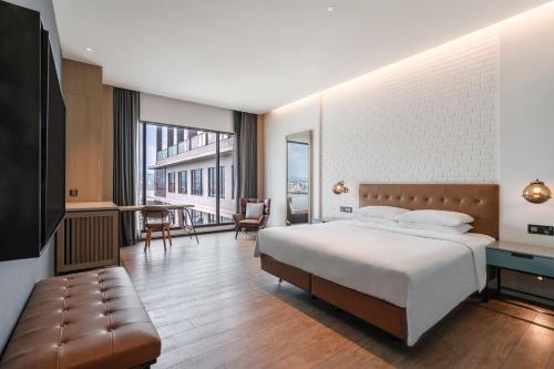a bedroom with a bed and a living room at Four Points by Sheraton Taipei Bali in Bali