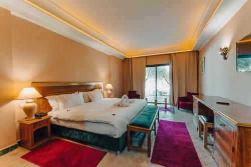 um quarto de hotel com uma cama e uma secretária em Palace Jena em Marrakech