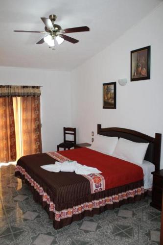 a bedroom with a bed and a ceiling fan at El Jardín Del Edén in Tequisquiapan