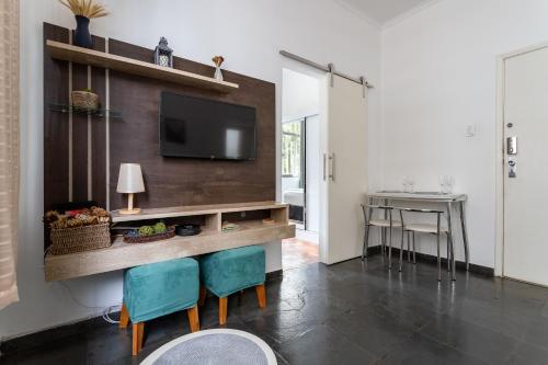 ein Wohnzimmer mit einem TV, einem Tisch und Stühlen in der Unterkunft Conforto em Botafogo - Ideal para casais - LM108 Z5 in Rio de Janeiro