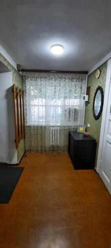 a room with a window and a table and a clock at Гостевой дом in Odesa