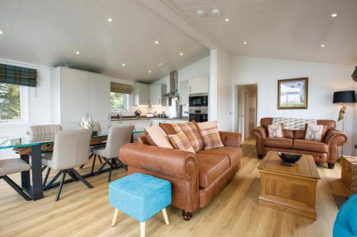een woonkamer met een bank en een tafel bij Drumcarrow Luxury Lodges in St Andrews