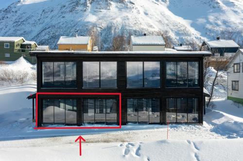 a house in the snow with a red arrow pointing to it at Skipperhuset leilighet nr 4 in Tofta