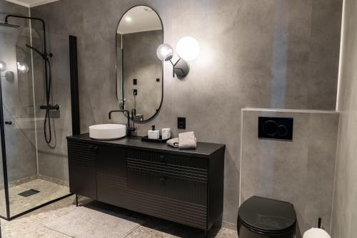 a bathroom with a sink and a mirror at Skipperhuset leilighet nr 4 in Tofta