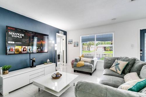 a living room with a couch and a tv at 5BD House - Pool+BBQ+King beds - 3 min to beach in Hollywood