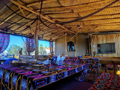 Habitación grande con mesa y sillas. en Qizilqum Safari Yurt Camp, en Narpay
