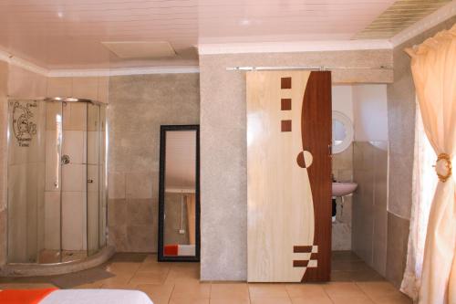 uma casa de banho com um chuveiro, um WC e um lavatório. em Godmill City Guesthouse Taung em Lethola