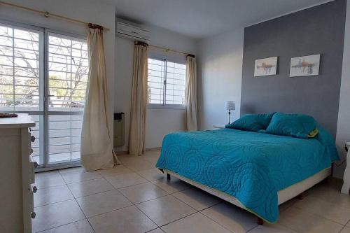 a bedroom with a bed with a blue comforter at Casa Pascal, Bº Villa Belgrano in Cordoba