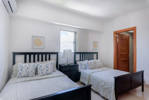 - une chambre avec 2 lits et une fenêtre dans l'établissement Brand New Harmony Apartment with Pool, Gym and Spa in La Julia, à Saint-Domingue
