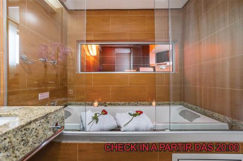 a bathroom with a bath tub with two towels at Motel Porto dos Casais in Porto Alegre