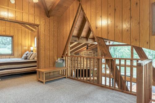 1 dormitorio con 1 cama en una cabaña de madera en Edgewater Escape by Sarah Bernard, with Hot Tub, en Innsbrook