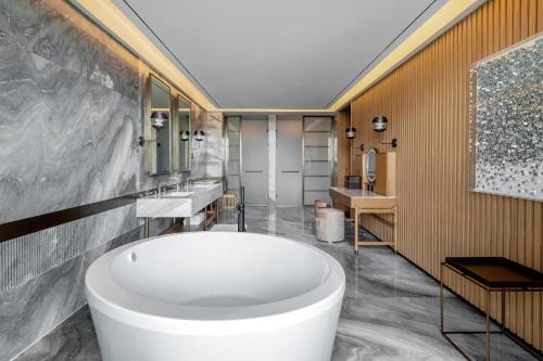 baño con bañera blanca grande y 2 lavabos en Sheraton Mianyang en Mianyang