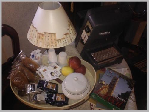 una tavola ricoperta da una lampada e da una ciotola di cibo di Affittacamere La Camelia a Lucca