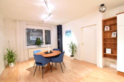 a dining room with a table and blue chairs at “Opera House” Apartment Graz - Self Check-In in Graz