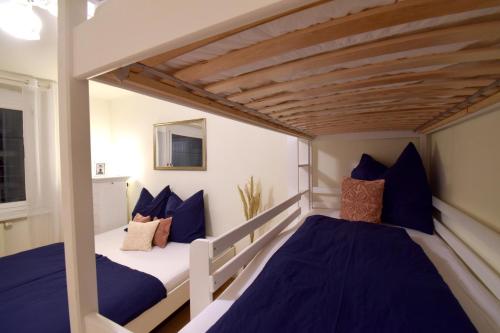 two beds in a small room with blue pillows at “Opera House” Apartment Graz - Self Check-In in Graz
