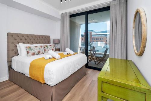 a bedroom with a large bed and a balcony at Rooftop with breathtaking views of Table Mountain. in Cape Town