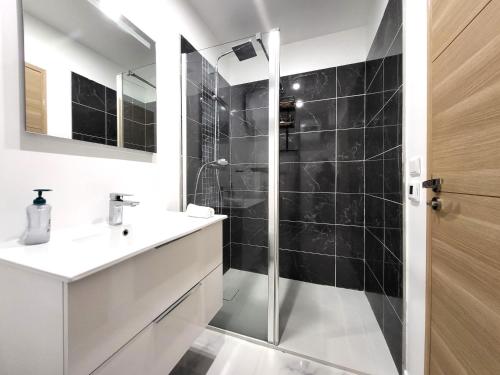 a bathroom with a shower and a white sink at Le Bellevue - Beaux appartements avec vue splendide in Palaiseau