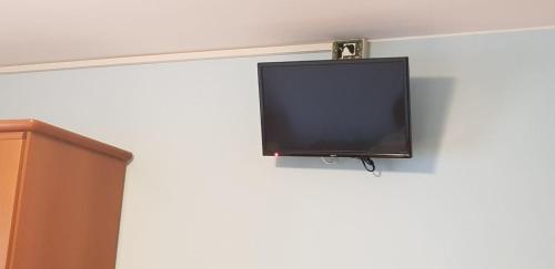 einen Flachbild-TV, der an einer Wand hängt in der Unterkunft Antica Corte da Edi in San Daniele del Friuli