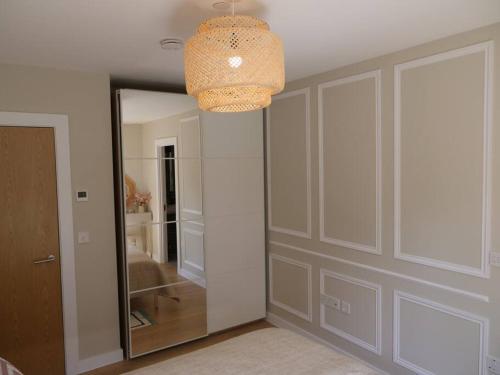 a room with a mirror and a chandelier at Vick's house in Uxbridge