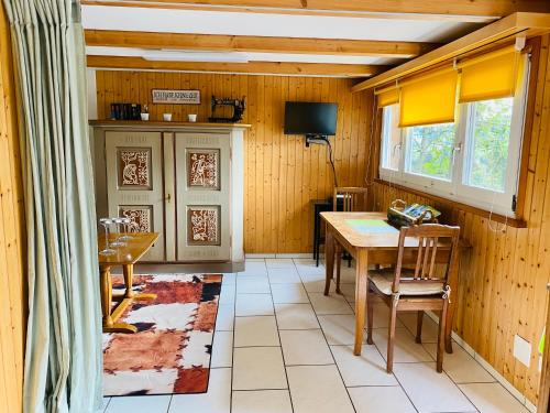 una sala da pranzo con tavolo e TV di Ferien auf dem Birkenhof a Herisau