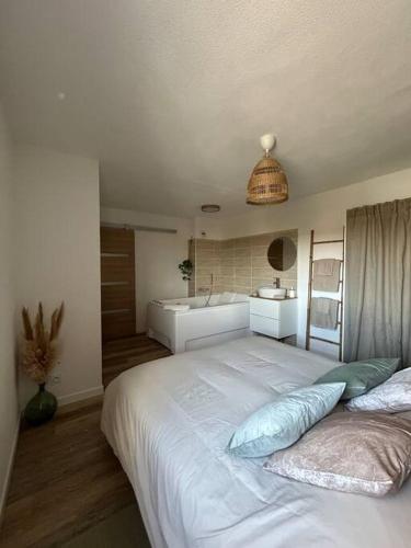 a bedroom with a large bed and a bathroom at Romantique Room in Muret