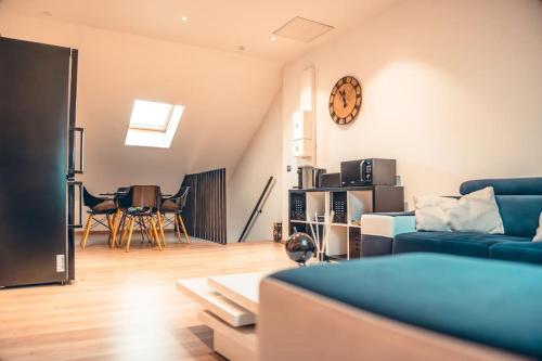 un salon avec un canapé et une horloge au mur dans l'établissement Les temps heureux, à Dunkerque