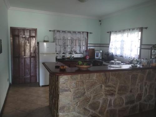 uma cozinha com um balcão de pedra e um frigorífico em Green House Jabaquara em Paraty